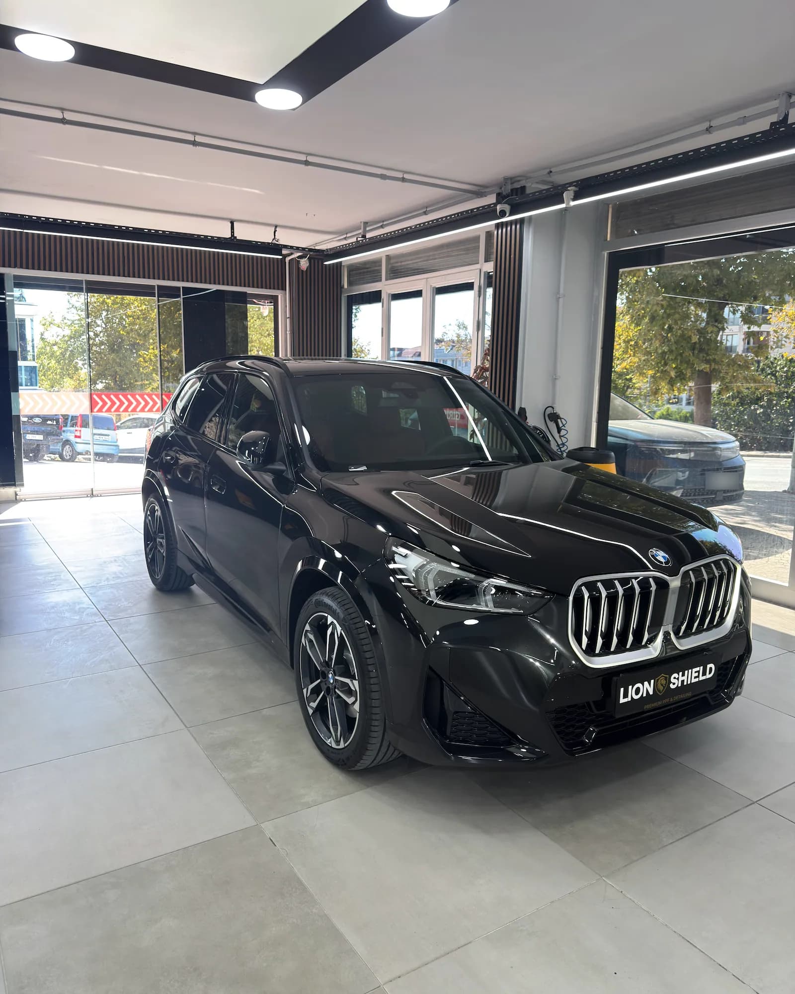 Uygulama merkezinde siyah BMW X1’in ön çaprazdan görünümü
