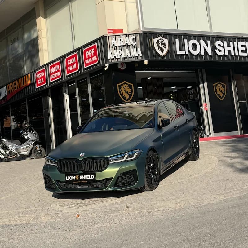 Uygulama merkezinin önünde mat yeşil BMW 5 Serisi